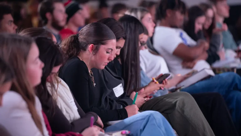 ngStudents taking notes during sermon.